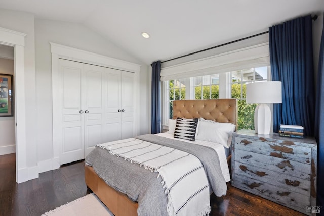 bedroom with a closet, lofted ceiling, baseboards, and wood finished floors