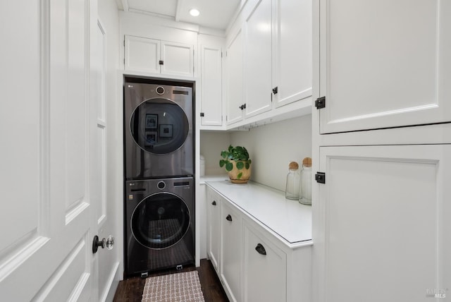 washroom featuring recessed lighting, cabinet space, stacked washer and clothes dryer, and dark wood-style floors