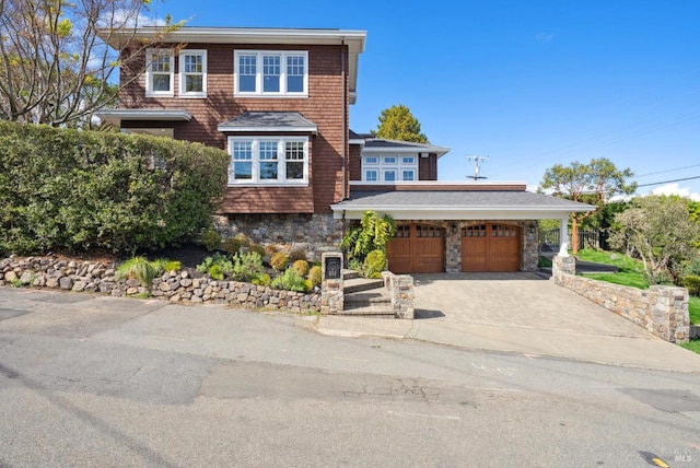 view of front of property with a garage, stone siding, and driveway