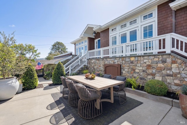 view of patio featuring outdoor dining space and stairs