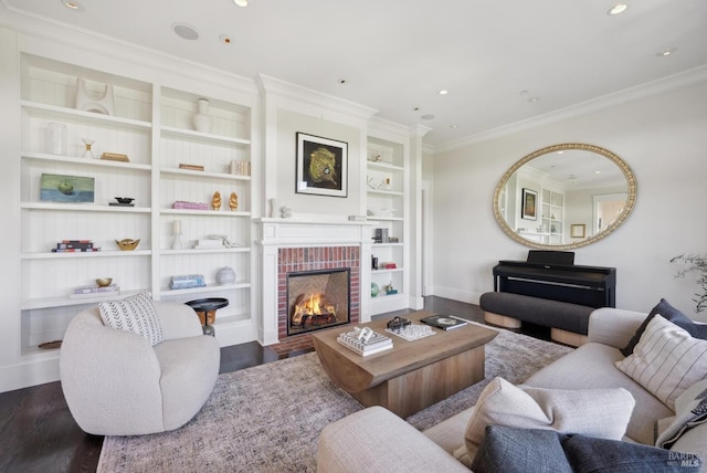 living area with ornamental molding, a brick fireplace, and wood finished floors