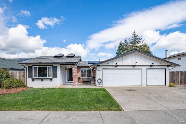 single story home featuring fence, driveway, a front lawn, a garage, and roof mounted solar panels