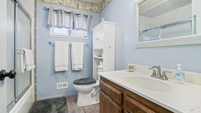 full bath featuring vanity, baseboards, visible vents, bath / shower combo with glass door, and toilet