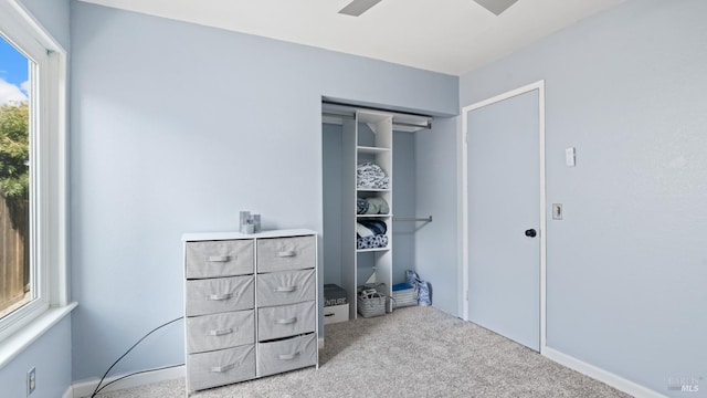 carpeted bedroom featuring a ceiling fan and a closet