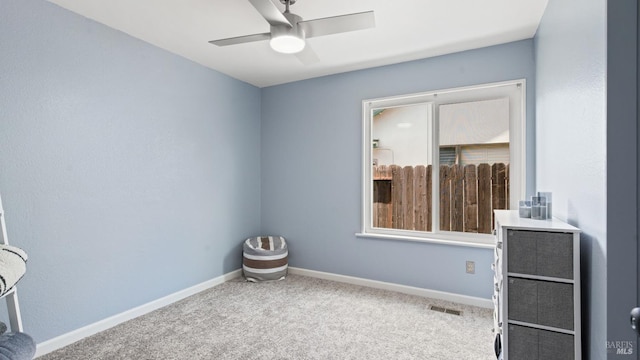 spare room featuring baseboards, visible vents, carpet floors, and ceiling fan