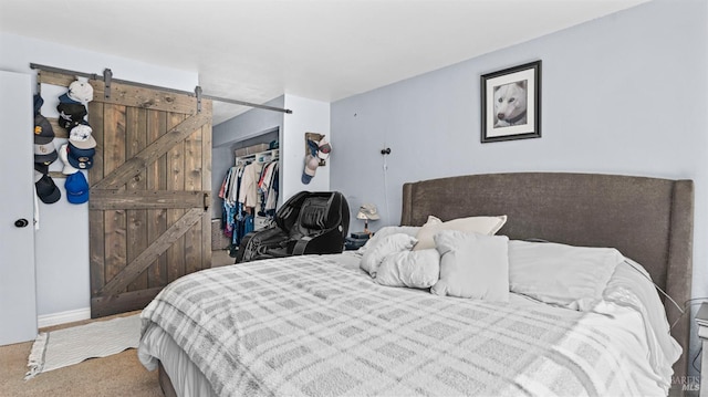 carpeted bedroom with a closet and a barn door