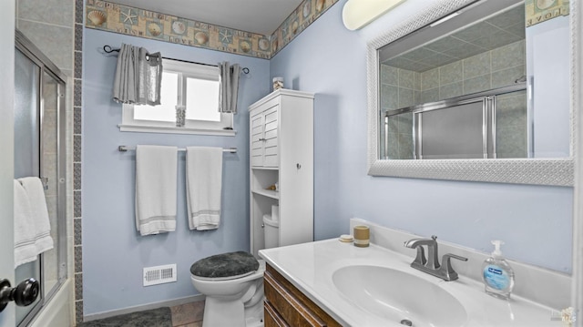 bathroom featuring visible vents, toilet, vanity, baseboards, and bath / shower combo with glass door