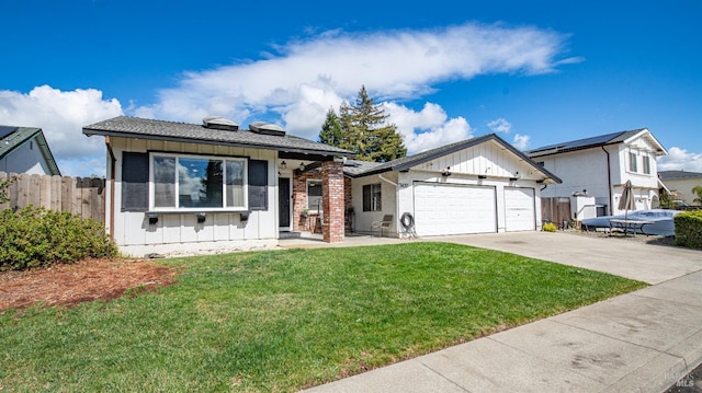 view of front facade with fence, driveway, a front lawn, a garage, and board and batten siding