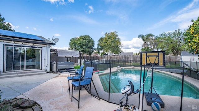 view of pool with a fenced in pool, a hot tub, a fenced backyard, an outdoor structure, and a patio area