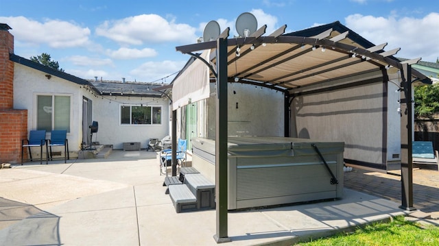 back of property featuring stucco siding, a pergola, a hot tub, and a patio