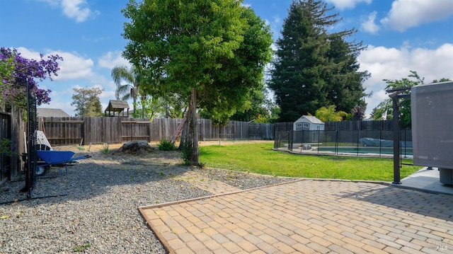 view of patio / terrace featuring a pool, an outbuilding, a shed, and a fenced backyard