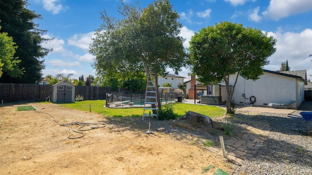 view of yard with an outdoor structure, a storage unit, a fenced in pool, and a fenced backyard