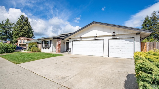 ranch-style home featuring an attached garage, concrete driveway, a front yard, and fence