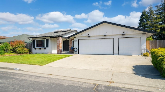 view of front of property featuring a front lawn, driveway, fence, an attached garage, and board and batten siding