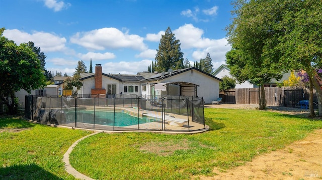 view of pool featuring a fenced backyard, a fenced in pool, a yard, and a diving board