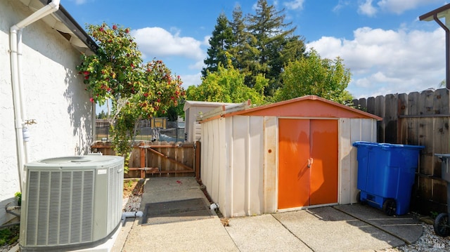 view of shed with fence, a gate, and cooling unit