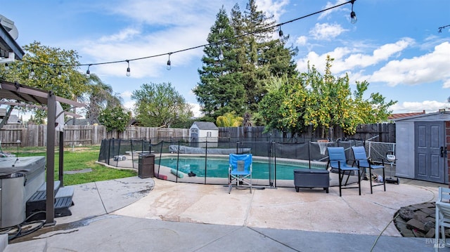 view of swimming pool with an outbuilding, a patio area, a storage unit, and a fenced backyard