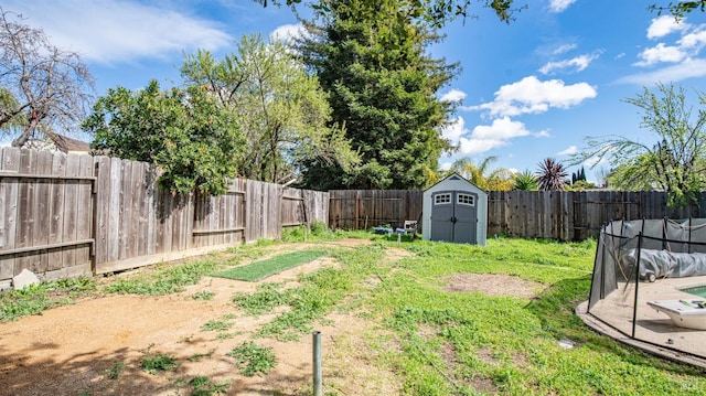 view of yard featuring a storage shed, an outdoor structure, and a fenced backyard