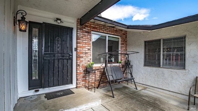 view of exterior entry featuring brick siding