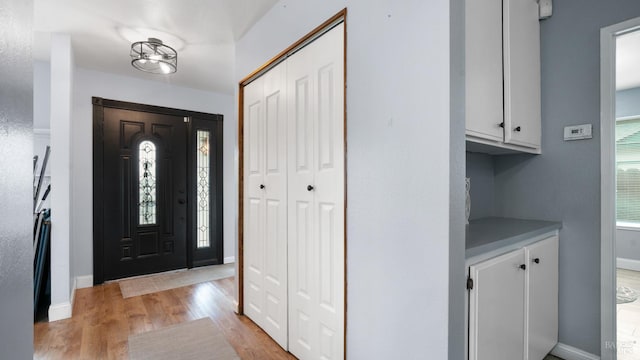 foyer featuring baseboards and light wood finished floors