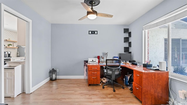 office featuring light wood-style flooring, a ceiling fan, and baseboards
