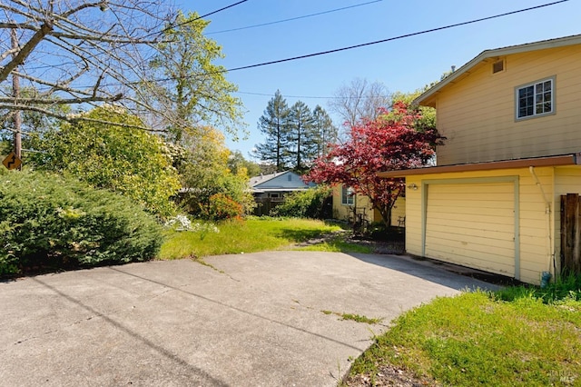 view of home's exterior featuring driveway and a yard