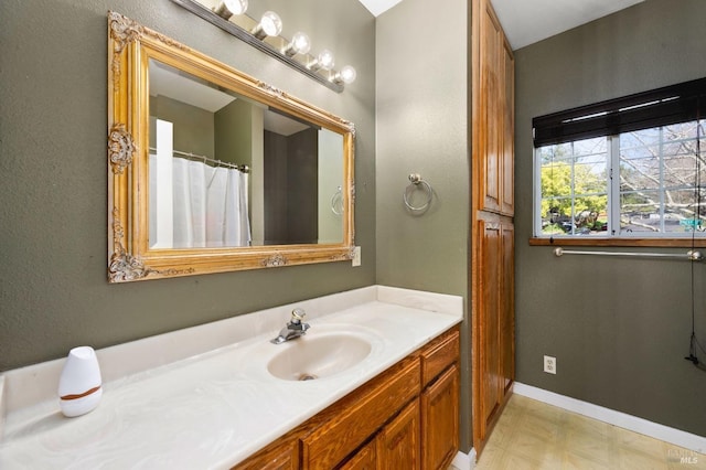 bathroom with baseboards, vanity, and tile patterned floors