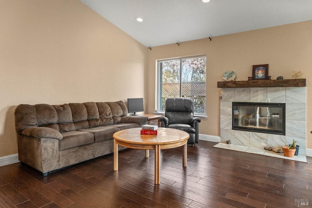 living room with baseboards, dark wood finished floors, a fireplace, and vaulted ceiling