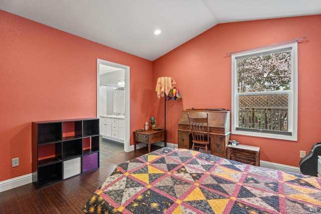 bedroom with lofted ceiling, wood finished floors, baseboards, and connected bathroom