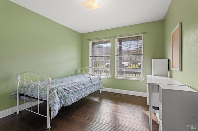 bedroom with wood finished floors, visible vents, and baseboards