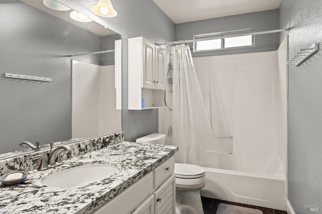 full bathroom featuring vanity, toilet, shower / bath combo with shower curtain, and a textured wall