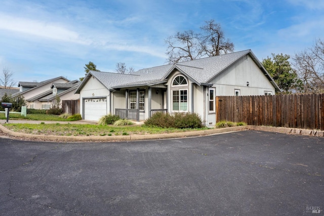 view of front of home featuring driveway, a porch, fence, a shingled roof, and a garage