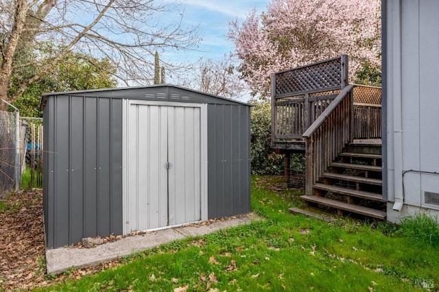 view of shed featuring stairway and fence