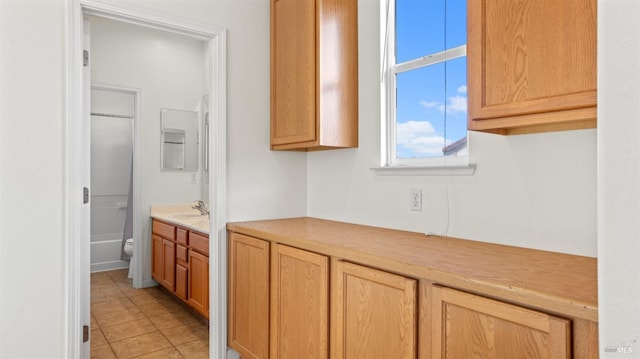 kitchen featuring light tile patterned flooring, light countertops, and a sink