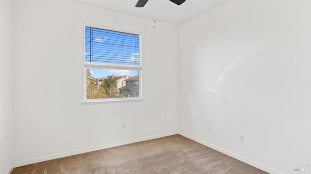 carpeted empty room featuring baseboards and ceiling fan