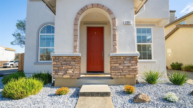 entrance to property with stone siding and stucco siding