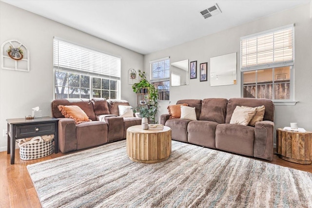 living area with wood finished floors and visible vents