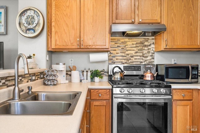 kitchen featuring ventilation hood, stainless steel appliances, light countertops, and a sink