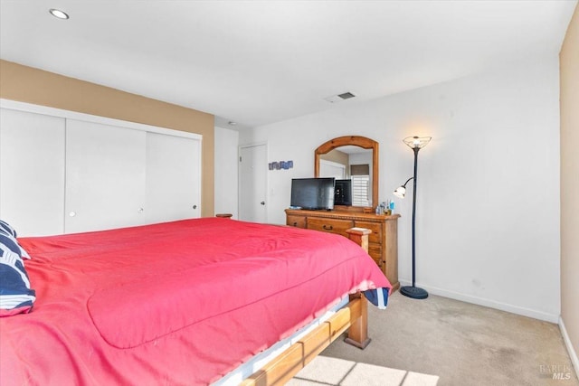 bedroom with a closet, visible vents, baseboards, and carpet floors