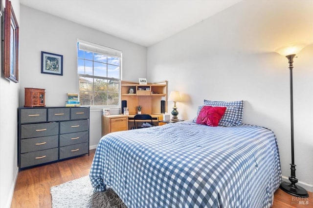 bedroom featuring baseboards and dark wood-style flooring