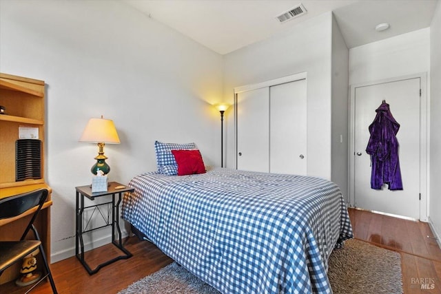 bedroom featuring visible vents, wood finished floors, a closet, and baseboards