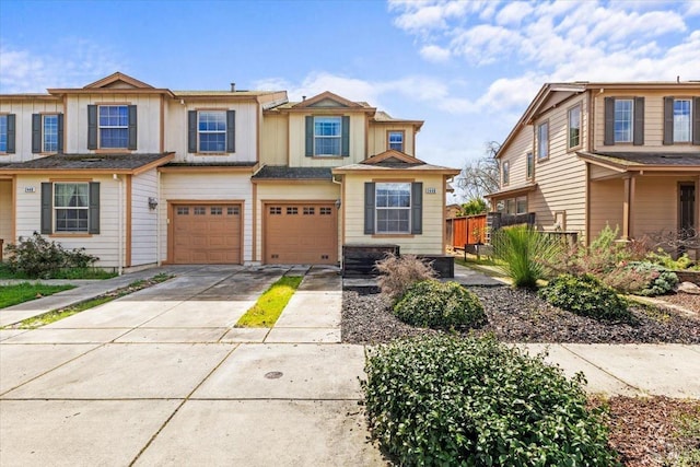 multi unit property featuring concrete driveway, an attached garage, fence, and board and batten siding