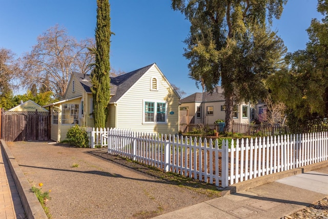 view of front facade featuring a fenced front yard and a shingled roof