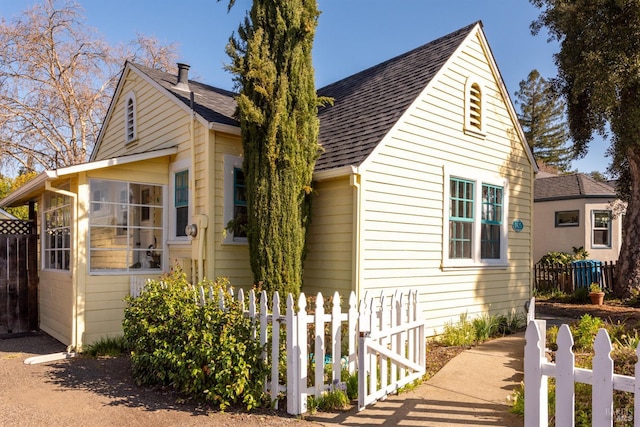 view of front of house featuring roof with shingles and fence