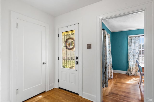 foyer featuring baseboards and wood finished floors