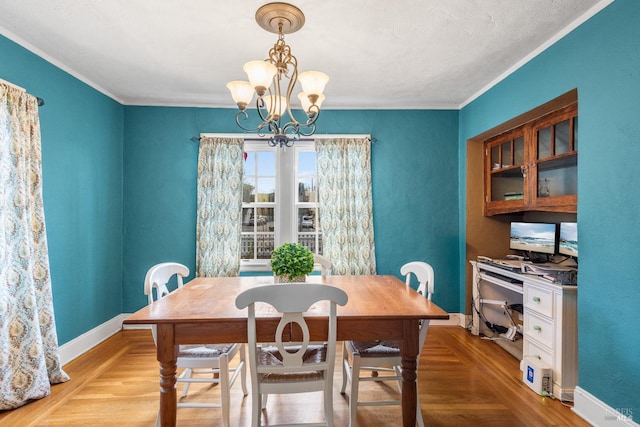 dining room featuring an inviting chandelier, baseboards, light wood finished floors, and ornamental molding