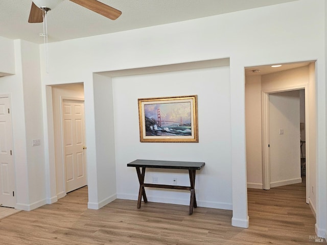 hallway featuring light wood-style floors and baseboards