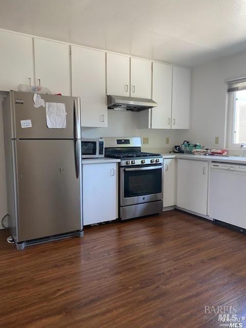 kitchen featuring light countertops, dark wood-style floors, under cabinet range hood, and stainless steel appliances