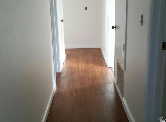 hall with baseboards and wood finished floors