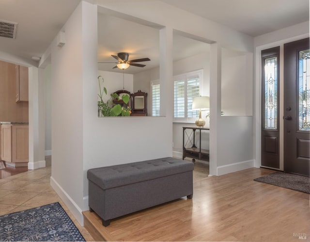 foyer featuring visible vents, baseboards, light wood-style floors, and ceiling fan